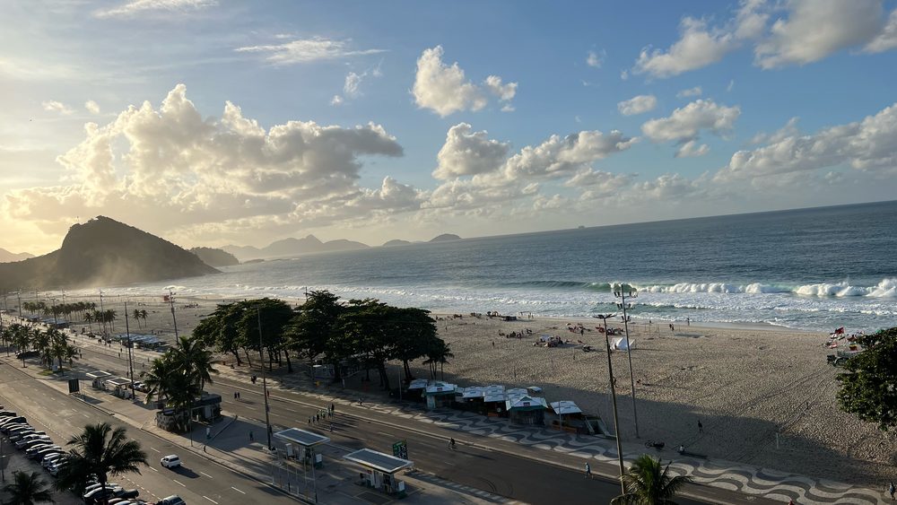 Copacabana beach from above: the curve of sand, the surf, and the hills along the bay
