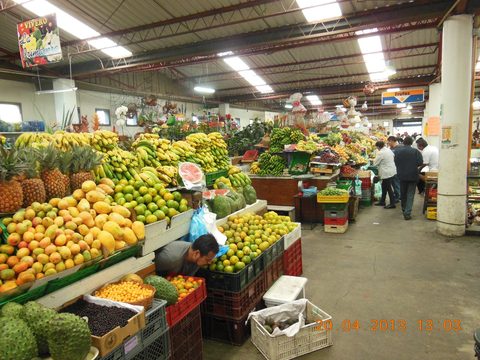 Fruit stalls piled with produce in a Bogota market hall