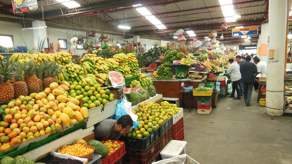 Fruit stalls piled with produce in a Bogota market hall