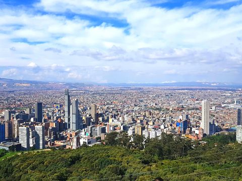 Wide view over Bogota with the Andes foothills under a blue sky