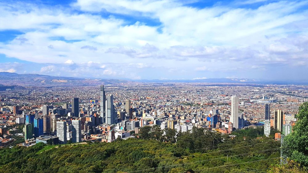 Wide view over Bogota with the Andes foothills under a blue sky