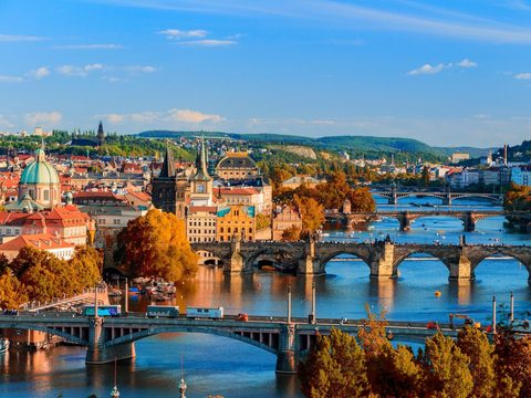 Prague skyline with the Vltava bridges and red roofs in autumn