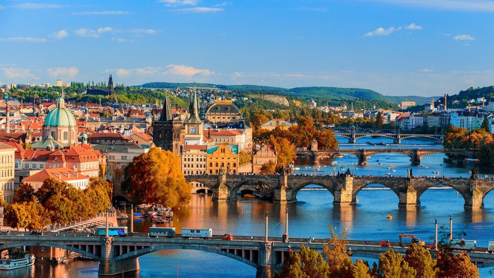 Prague skyline with the Vltava bridges and red roofs in autumn