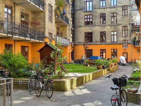 Sunny Copenhagen apartment courtyard with bicycles and garden