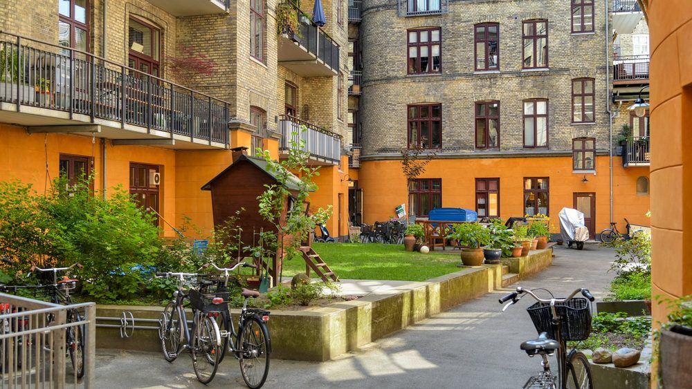 Sunny Copenhagen apartment courtyard with bicycles and garden