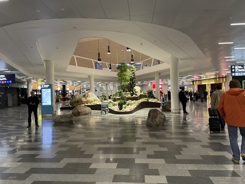 Arrivals hall at Helsinki Airport with a planted indoor garden