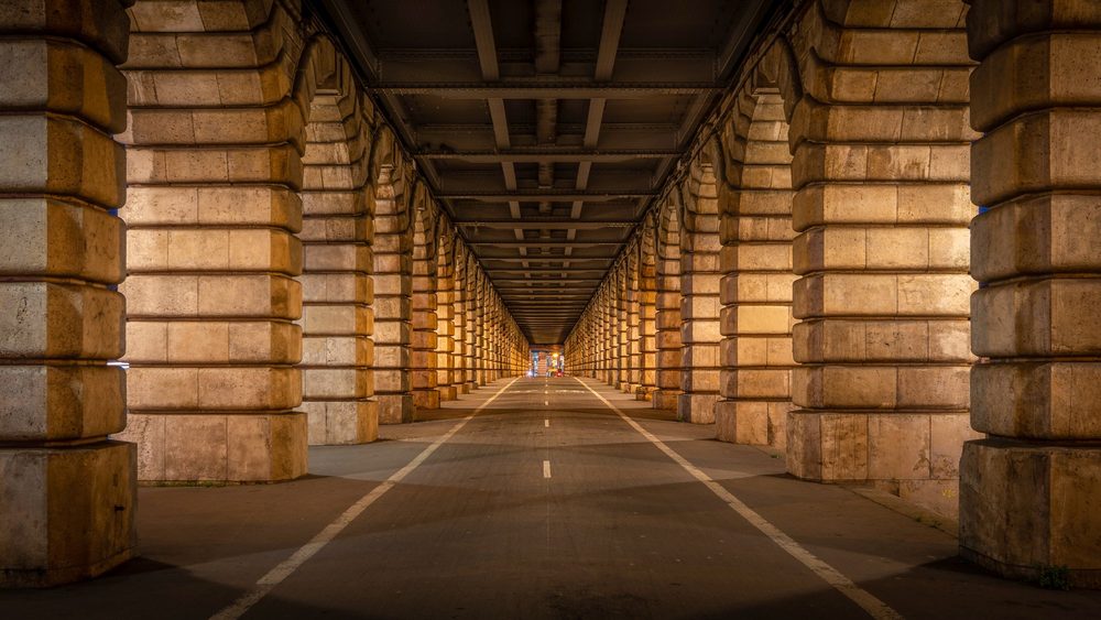 Long arched walkway beneath the Pont de Bercy in Paris