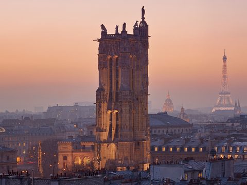 Tour Saint-Jacques tower in Paris at dusk with the Eiffel Tower behind