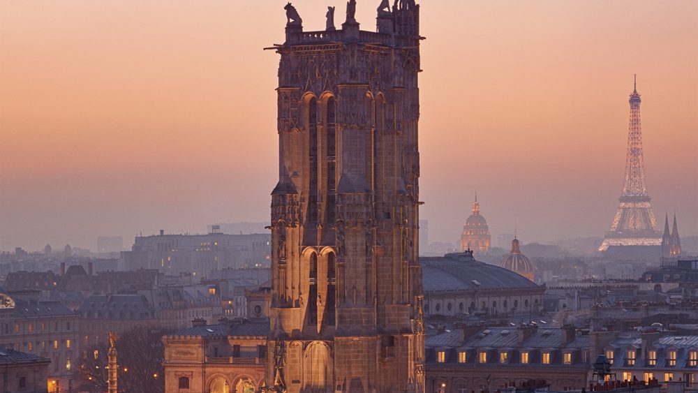 Tour Saint-Jacques tower in Paris at dusk with the Eiffel Tower behind