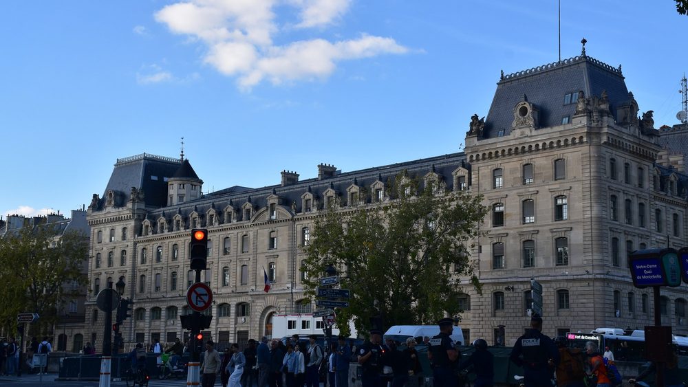 The Prefecture de Police building on the Ile de la Cite in Paris, with traffic and pedestrians on the street in front