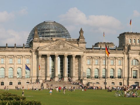 The Reichstag building in Berlin with its glass dome and lawn