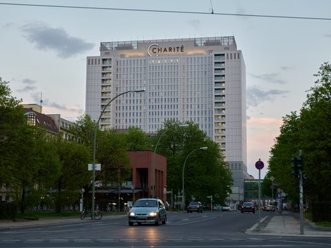 Charite hospital tower in Berlin with a tree-lined street in front