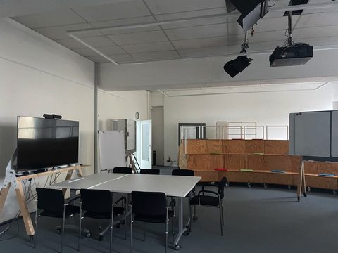 Empty meeting room in a German office with tables and screens