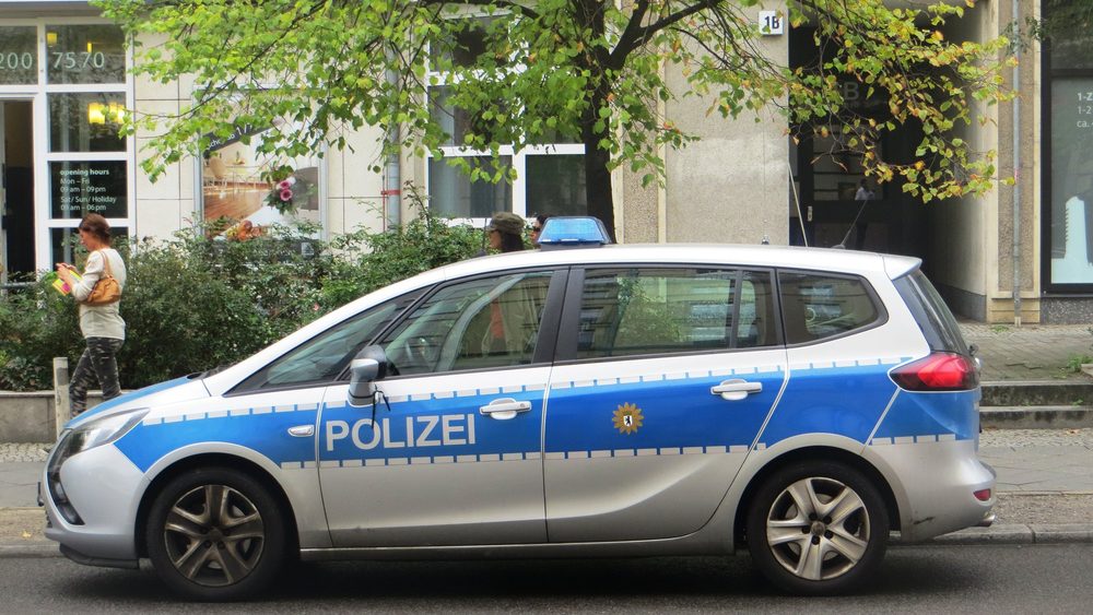 Blue and silver Berlin Polizei patrol car parked on a street