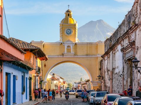 Santa Catalina Arch in Antigua Guatemala with a volcano behind it