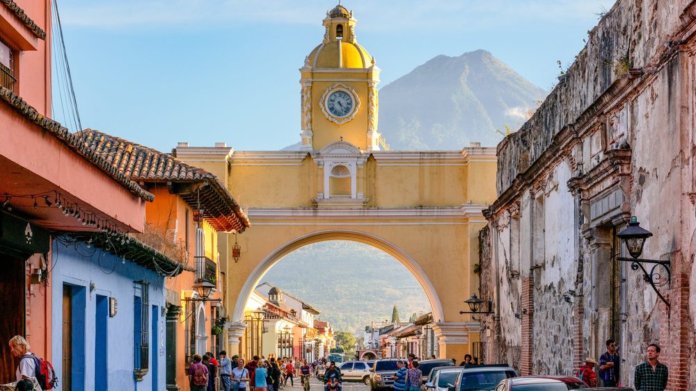 Santa Catalina Arch in Antigua Guatemala with a volcano behind it