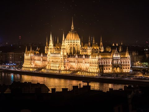 Hungarian Parliament Building lit up at night across the Danube in Budapest, Hungary