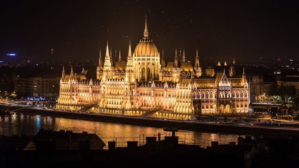 Hungarian Parliament Building lit up at night across the Danube in Budapest, Hungary