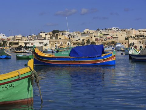 Colorful luzzu fishing boats in Marsaxlokk harbor