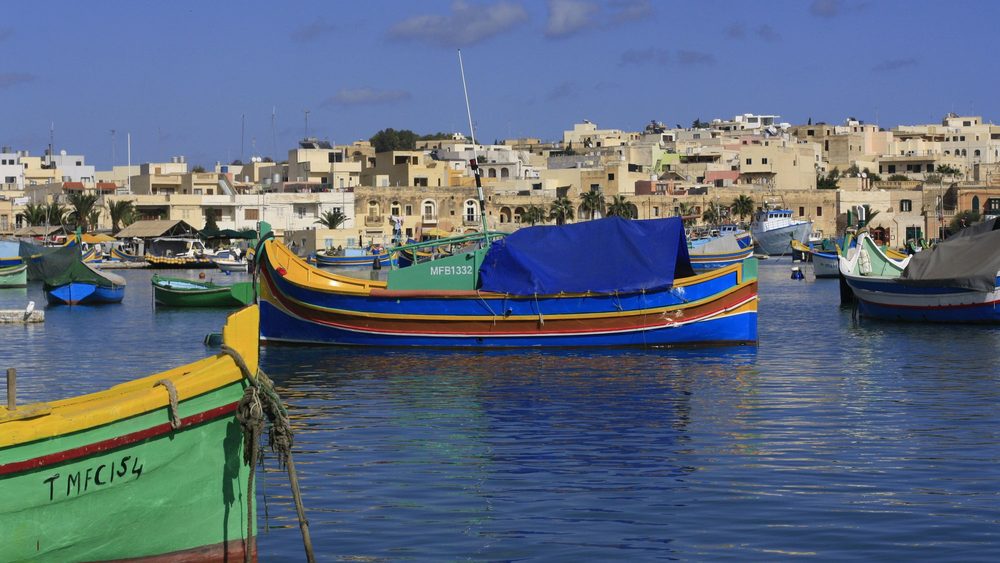 Colorful luzzu fishing boats in Marsaxlokk harbor