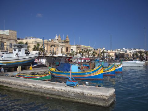 Colorful luzzu fishing boats in Marsaxlokk harbour, Malta