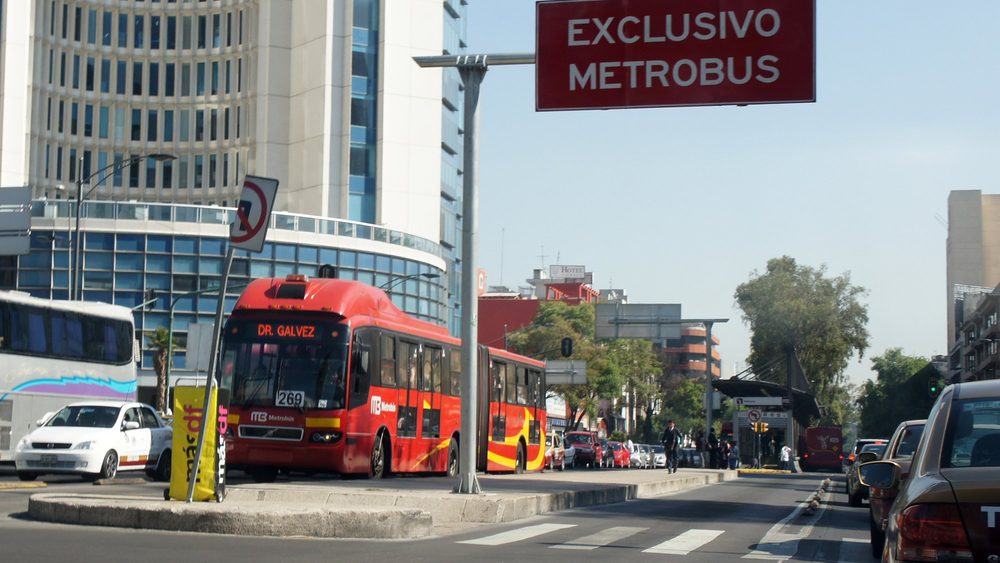 Red Metrobus articulated bus at a dedicated lane station in Mexico City