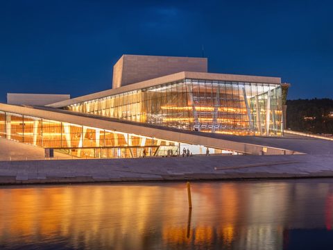Oslo Opera House glowing at dusk on the Bjorvika waterfront