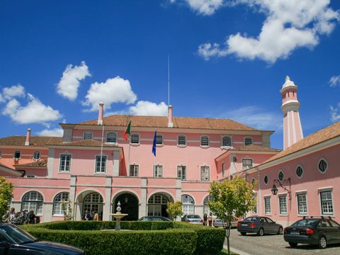 Pink government palace building in Lisbon with a red-striped tower