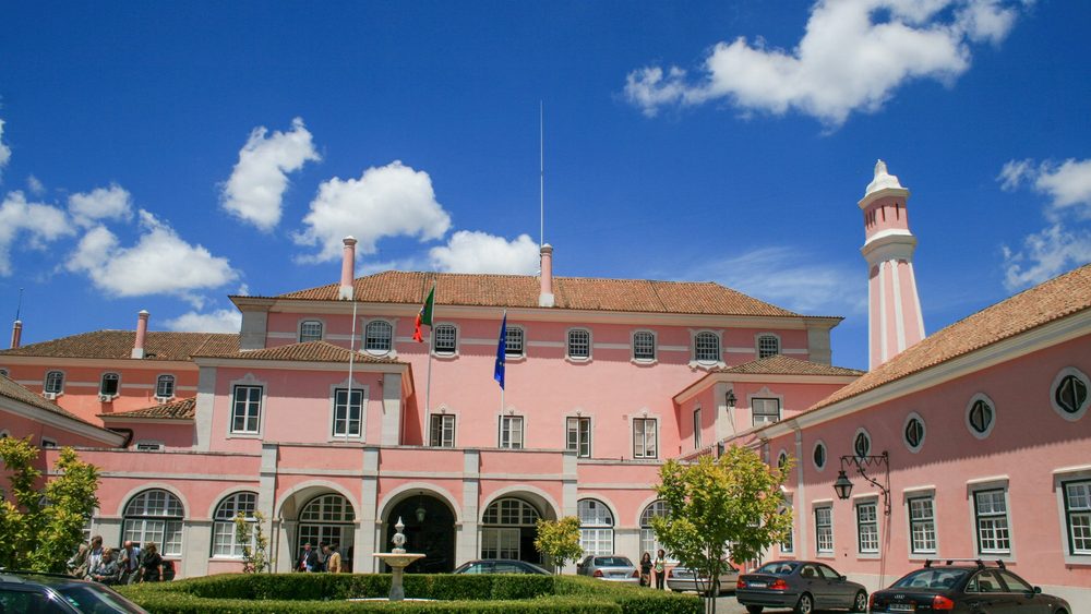 Pink government palace building in Lisbon with a red-striped tower