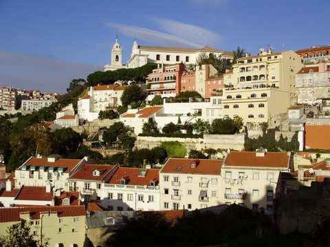 Hillside old town of Lisbon with pastel houses and church towers