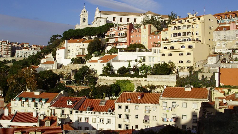 Hillside old town of Lisbon with pastel houses and church towers