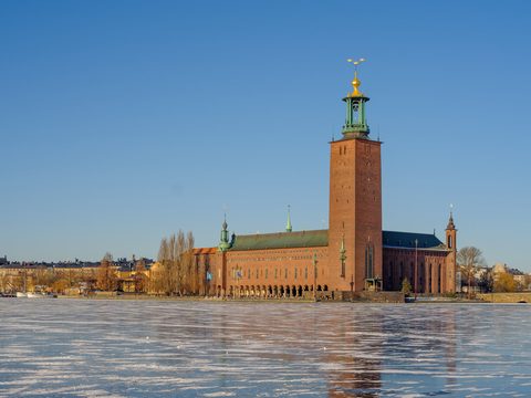 Stockholm City Hall tower rising over the frozen bay in winter