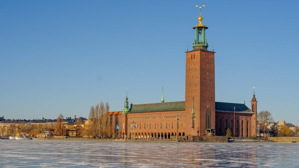 Stockholm City Hall tower rising over the frozen bay in winter