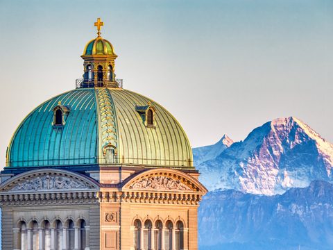 Dome of the Swiss Federal Palace in Bern with the Eiger behind