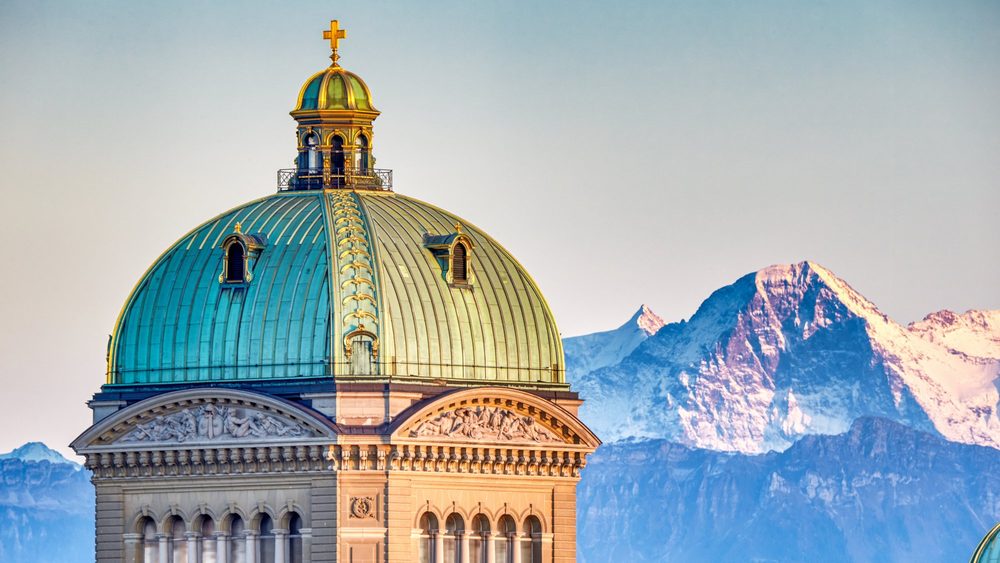 Dome of the Swiss Federal Palace in Bern with the Eiger behind
