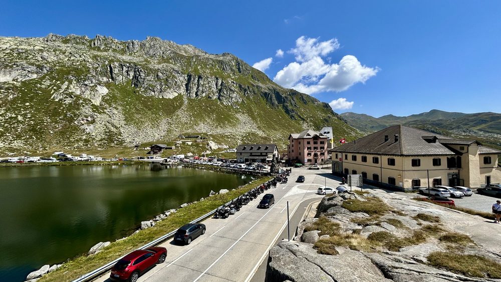 Road over the Saint Gotthard Pass with cars beside the mountain lake