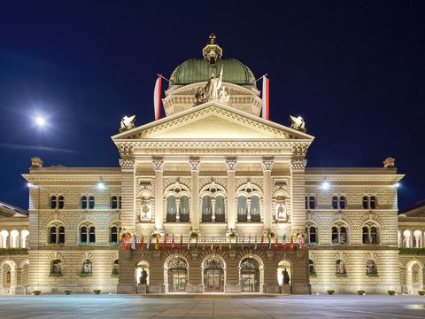 The Federal Palace in Bern at night, seen across the flagged Bundesplatz