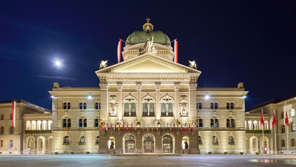 The Federal Palace in Bern at night, seen across the flagged Bundesplatz